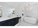 Large bathroom featuring marble counters, soaking tub, and modern finishes at 7217 Manor Oaks Dr, Raleigh, NC 27615