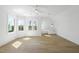 Bright bedroom featuring hardwood floors, a ceiling fan, and abundant natural light from large windows at 7217 Manor Oaks Dr, Raleigh, NC 27615