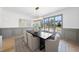 Bright dining room featuring hardwood floors, elegant lighting fixture, and views of the outdoors through large windows at 7217 Manor Oaks Dr, Raleigh, NC 27615