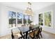 Bright dining room features large windows with scenic views, an elegant light fixture and modern decor at 7217 Manor Oaks Dr, Raleigh, NC 27615