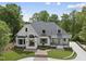 Two-story brick home with manicured landscaping, curved driveway and a welcoming front porch at 7217 Manor Oaks Dr, Raleigh, NC 27615