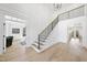 Light filled foyer with high ceilings, beautiful hardwood floors, and a modern staircase with black railings at 7217 Manor Oaks Dr, Raleigh, NC 27615