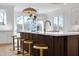 Kitchen island with quartz countertop, bar stool seating, a stainless steel dishwasher, and brass fixtures at 7217 Manor Oaks Dr, Raleigh, NC 27615