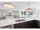 Bright, open kitchen with an island, modern lighting, stainless steel appliances, and a view into the living room at 7217 Manor Oaks Dr, Raleigh, NC 27615