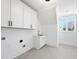 Bright laundry room featuring tile floors, white cabinets, a sink and a window at 7217 Manor Oaks Dr, Raleigh, NC 27615