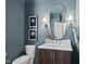 Powder room with designer mirror, vanity, and fixtures at 7217 Manor Oaks Dr, Raleigh, NC 27615