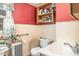 Compact bathroom with red and cream walls, essential fixtures, and a window at 7534 Overhills Rd, Spring Lake, NC 28390