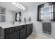 Bathroom with double sinks, black cabinets, and a large mirror and natural light at 778 Cabin Branch Dr, Fuquay Varina, NC 27526