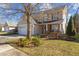 Two-story home with a two-car garage, stone-accented entryway, and blossoming front yard at 778 Cabin Branch Dr, Fuquay Varina, NC 27526