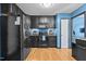 Bright kitchen featuring dark cabinets, stainless appliances, and hardwood floors at 778 Cabin Branch Dr, Fuquay Varina, NC 27526
