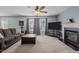 Bright living room featuring neutral carpet, a ceiling fan, fireplace, and a comfortable seating area at 778 Cabin Branch Dr, Fuquay Varina, NC 27526