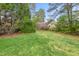 Well-manicured backyard with a lush green lawn and mature trees, creating a peaceful and private retreat at 8 Bryncastle Ct, Durham, NC 27707