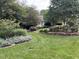 Landscaped front yard with manicured lawn, flower beds, and mature trees, enhancing the home's curb appeal at 8 Bryncastle Ct, Durham, NC 27707