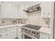 This kitchen features white cabinets and modern, stainless steel appliances, including a Wolf brand oven and stovetop at 8 Bryncastle Ct, Durham, NC 27707