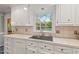 This kitchen shows lots of white cabinetry, a stainless steel sink, and a window with a view of the backyard at 8 Bryncastle Ct, Durham, NC 27707