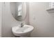 Cozy half bath with a pedestal sink, oval mirror, and natural light at 8412 Lunar Stone Pl, Raleigh, NC 27613