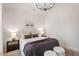 Bright bedroom with neutral decor, two end tables and modern chandelier at 8412 Lunar Stone Pl, Raleigh, NC 27613
