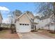 Tan two-story home featuring a two-car garage and manicured lawn at 8412 Lunar Stone Pl, Raleigh, NC 27613
