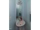 A small bathroom featuring a pedestal sink with faucet and mirror at 9845 Sweet Basil Dr, Wake Forest, NC 27587