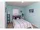 A well-lit bedroom with light blue walls, a comfortable bed, and bright natural light at 9845 Sweet Basil Dr, Wake Forest, NC 27587