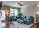 Cozy living room features hardwood floors, natural light, and comfortable blue sofa with an ottoman at 9845 Sweet Basil Dr, Wake Forest, NC 27587