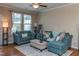 Cozy living room featuring comfortable sofas, a decorative rug, and large windows at 9845 Sweet Basil Dr, Wake Forest, NC 27587