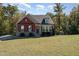 Charming two-story home with a mix of brick and siding, surrounded by mature trees at 1001 Jarrett Bay Rd, Willow Springs, NC 27592
