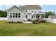 Expansive backyard with a patio, lush lawn, blooming flowers, and a charming covered porch at 1001 Peterson Ridge Rd, Fuquay Varina, NC 27526