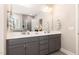 Elegant bathroom featuring a double vanity, large mirror, and neutral gray tile at 1001 Peterson Ridge Rd, Fuquay Varina, NC 27526