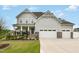 Charming two-story home featuring a manicured lawn, inviting porch, and three-car garage at 1001 Peterson Ridge Rd, Fuquay Varina, NC 27526