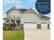 Stunning two-story home featuring a three-car garage, a landscaped yard and a charming front porch at 1001 Peterson Ridge Rd, Fuquay Varina, NC 27526