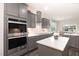 A modern kitchen features gray cabinets, stainless steel appliances, and an island with a white countertop at 1001 Peterson Ridge Rd, Fuquay Varina, NC 27526