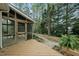 Inviting screened-in porch leads to a wooded backyard with a brick paver path and lush green foliage at 1007 Surry Dale Ct, Apex, NC 27502