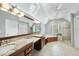 Luxurious bathroom featuring double sinks, soaking tub, skylight, and a glass enclosed shower at 1007 Surry Dale Ct, Apex, NC 27502