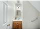 Compact powder room featuring a wood vanity, mirror, and convenient grab bar at 1007 Surry Dale Ct, Apex, NC 27502