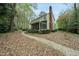 Back exterior of home with brick chimney, covered porch, leading to patio and gardens, creating a serene setting at 1007 Surry Dale Ct, Apex, NC 27502