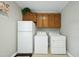 Functional laundry room with upper cabinets, washer, dryer, and refrigerator for added convenience at 1007 Surry Dale Ct, Apex, NC 27502