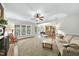 Bright living room featuring a brick fireplace, ceiling fan, and large windows, offering a cozy and inviting atmosphere at 1007 Surry Dale Ct, Apex, NC 27502