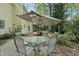 Inviting patio area with umbrella and comfortable seating, perfect for outdoor dining or entertaining, surrounded by lush trees at 1007 Surry Dale Ct, Apex, NC 27502