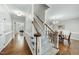 Bright foyer with hardwood floors and carpeted stairs with wooden railings leading upstairs at 1007 Surry Dale Ct, Apex, NC 27502