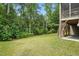 Backyard featuring trees in the back, a lush lawn, and a patio, creating a serene and private outdoor setting at 1056 Lukestone Dr, Fuquay Varina, NC 27526