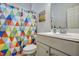 Bathroom with a single sink vanity, mirror, and a colorful patterned shower curtain at 1056 Lukestone Dr, Fuquay Varina, NC 27526