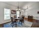 Bright dining room with hardwood floors, a classic chandelier, and a view of the front yard at 1056 Lukestone Dr, Fuquay Varina, NC 27526