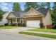 Well-maintained single-story home featuring brick and siding, an attached garage, and a tidy front lawn at 1056 Lukestone Dr, Fuquay Varina, NC 27526