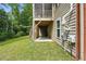 Home exterior with wood siding, screened in porch, stairs, green grass, and surrounding woods at 1056 Lukestone Dr, Fuquay Varina, NC 27526