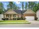 Charming single-story brick home with a manicured lawn, covered porch, and attached two-car garage at 1056 Lukestone Dr, Fuquay Varina, NC 27526