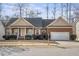 Charming brick home with a covered front porch and well-manicured landscaping at 1056 Lukestone Dr, Fuquay Varina, NC 27526