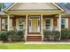 Inviting front porch with a classic brick facade, hanging flower baskets, and rocking chairs at 1056 Lukestone Dr, Fuquay Varina, NC 27526