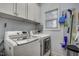Practical laundry room with modern washer and dryer, white cabinetry and organization at 1056 Lukestone Dr, Fuquay Varina, NC 27526