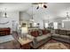 Open-concept living room with a neutral sofa, hardwood floors, and an open kitchen with breakfast bar seating at 1056 Lukestone Dr, Fuquay Varina, NC 27526